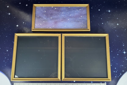 Three gold-framed mirrors on a dark blue background with a ruler at the bottom.