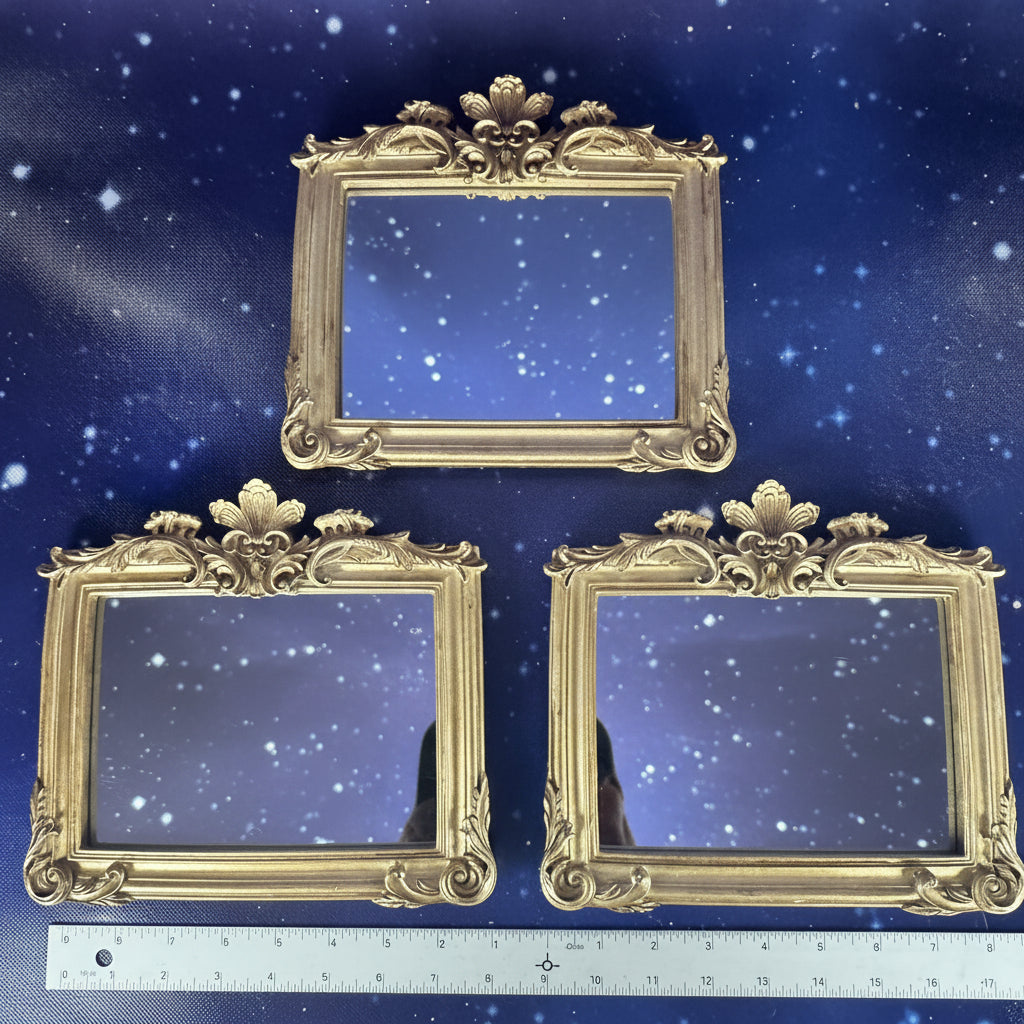 Three ornate gold picture frames on a blue background with a ruler for scale.