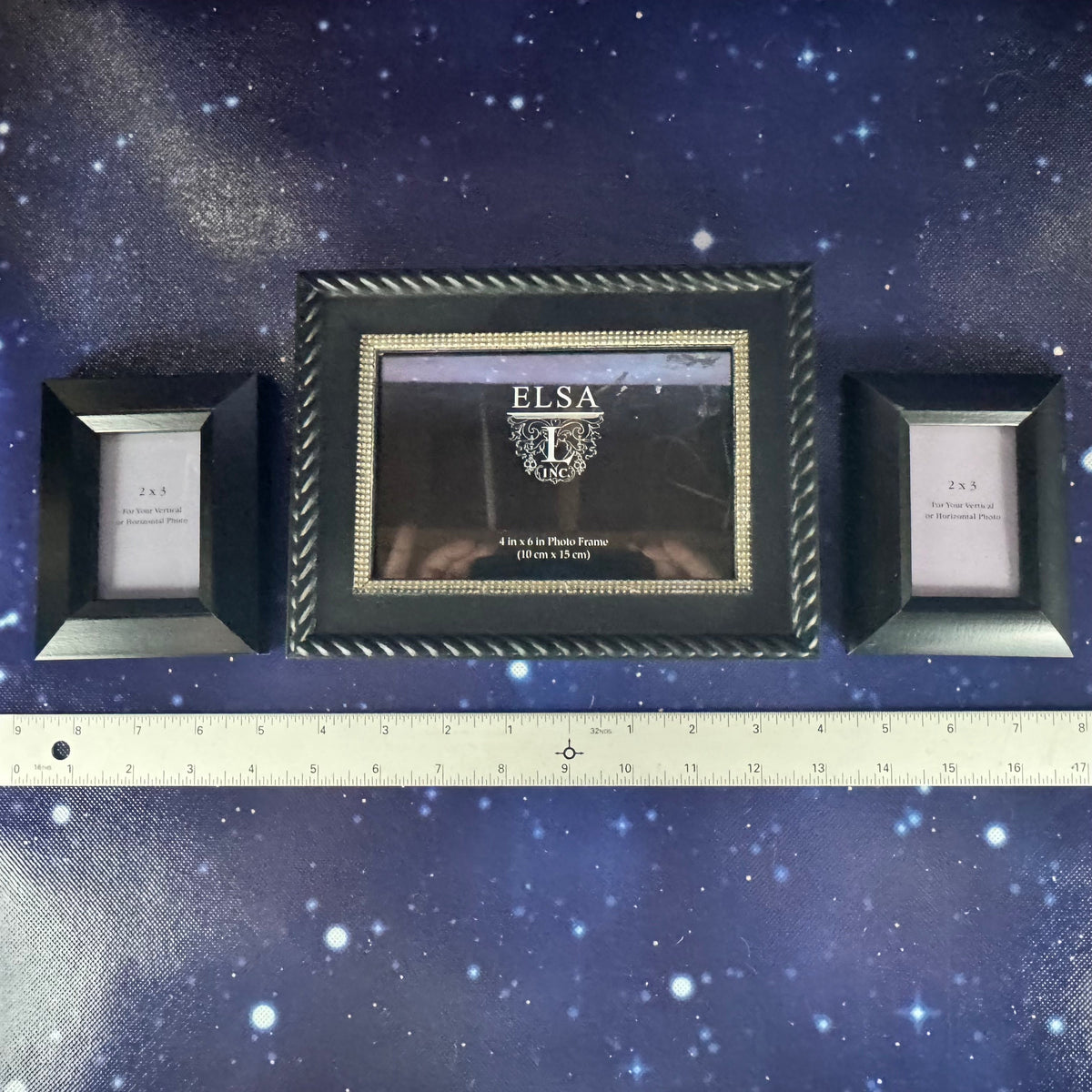 Three black photo frames with 'ELSA' branding on a starry background