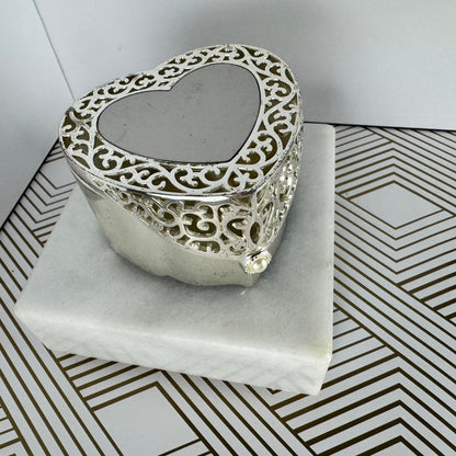 Silver-toned, heartshaped jewelry box with faux pearl clasp. Velvet-lined interior.