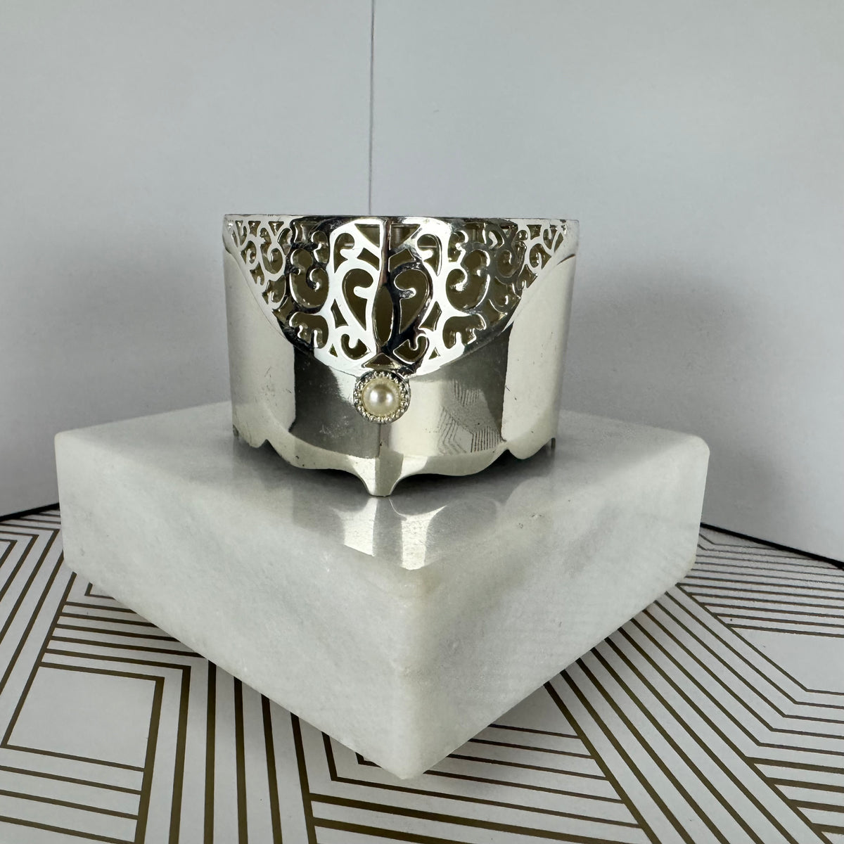 Silver-toned, heartshaped jewelry box with faux pearl clasp. Velvet-lined interior.