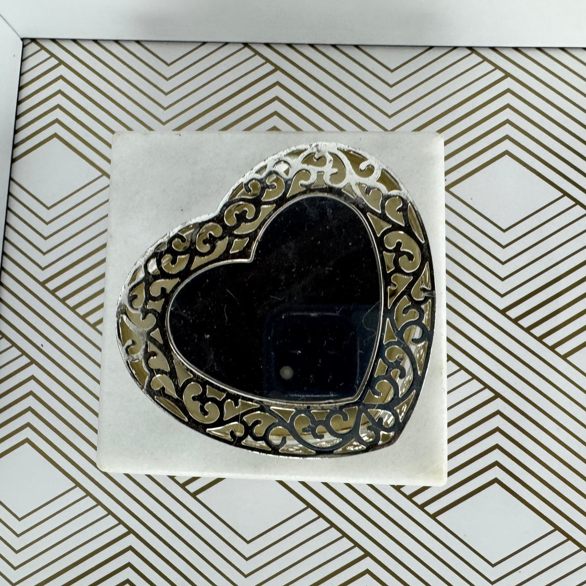 Silver-toned, heartshaped jewelry box with faux pearl clasp. Velvet-lined interior.