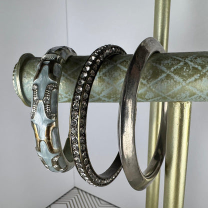 Three silver rings on a decorative metal rod with a white background