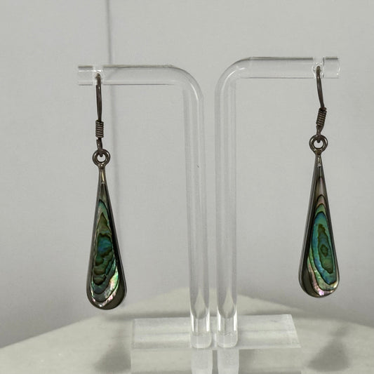 Teardrop-shaped earrings with green and black pattern on a clear stand against a white background