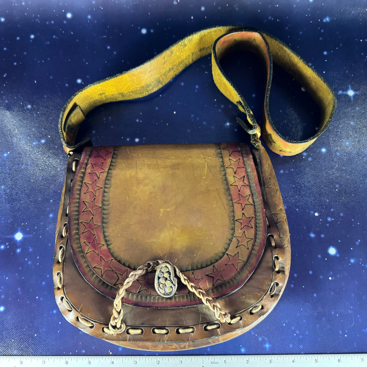 Brown leather bag with star patterns on a blue fabric background