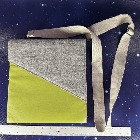 Crossbody bag with gray top half and green bottom half on a starry night background with a ruler at the bottom.