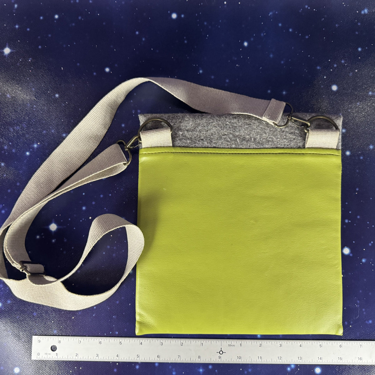 Green bag with a gray strap on a starry night sky background
