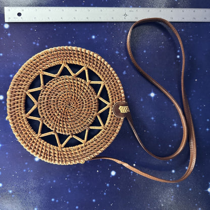 Woven handbag with a strap on a blue textured background