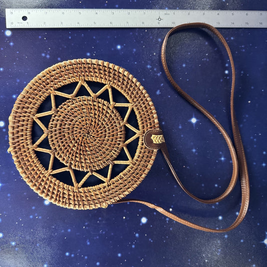 Woven handbag with a strap on a blue textured background